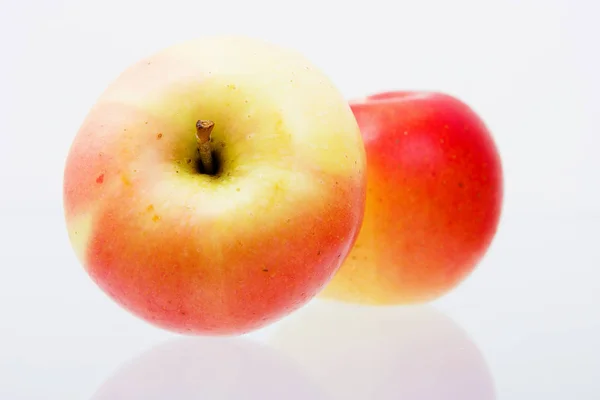 2つの熟した赤いリンゴが反射面にあり — ストック写真