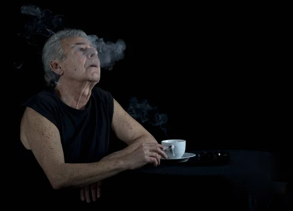 Anciano Sentado Mesa Bebiendo Café Fumando Cigarrillo —  Fotos de Stock