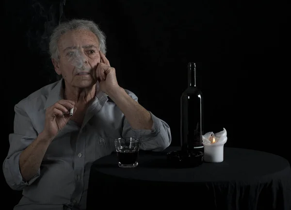 Yaşlı Adam Masada Oturmuş Şarap Içiyor Sigara Içiyor — Stok fotoğraf
