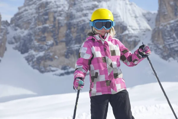 穿着滑雪服的年轻女子坐在雪地上 — 图库照片