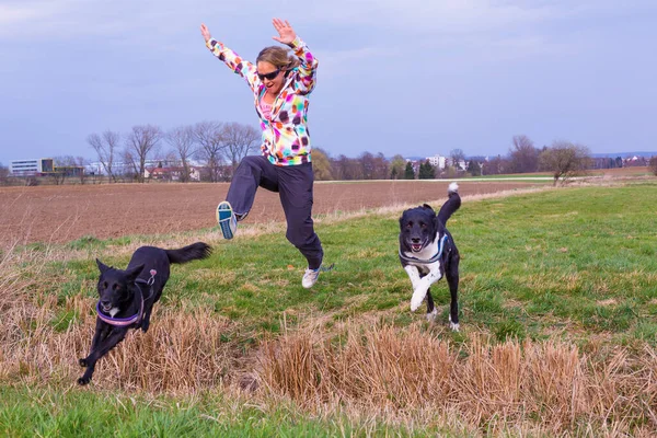 若い女性が犬と一緒に溝を飛び越えて — ストック写真