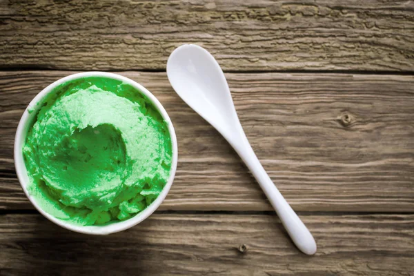 Высокоугольный Крупный План Круглого Контейнера Полного Вкусного Зеленого Фисташкового Мороженого — стоковое фото