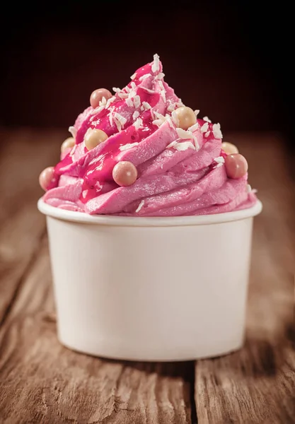 派对上的装饰粉红浆果冰淇淋放在一个塑料浴缸里 放在一个黑色背景的乡村木制柜台上 闭合低角度的视野 — 图库照片
