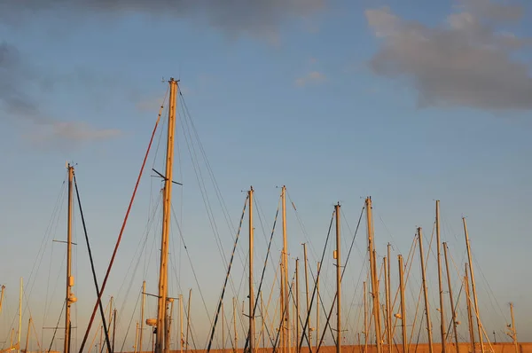 日没の背景を持つポートで帆ボートマスト — ストック写真