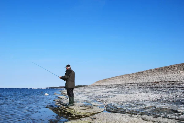 Homem Pescando Uma Costa Rocha Plana Céu Azul Água Azul — Fotografia de Stock