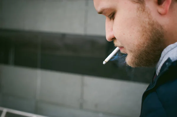 留着小胡子 胡子男人抽着烟 与情绪的脸 在露天的肖像 — 图库照片