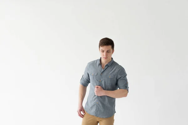 年轻英俊的男子 体格强壮 身穿衬衫和棕色裤子 背景为白色 — 图库照片