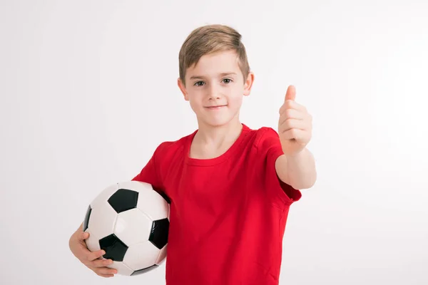 Chłopiec Czerwonej Koszuli Piłką Nożną Kciuk Góry Przed Białym Tle — Zdjęcie stockowe