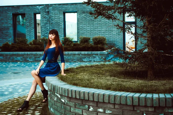 長い髪の長い脚を持つ若い魅力的な女性剣ベルト付きの青エレガントなドレスで ヨーロッパの近代的な中庭で 暖かい夏の日に散歩 — ストック写真
