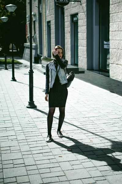 黒のバックパックとデニムジャケット秋の晴れた日で 黒の服を身に着けている女の子の学生のストリートポートレート — ストック写真