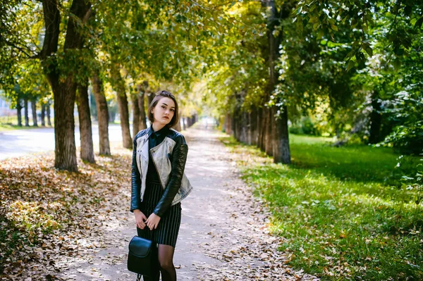 一个女学生的街头肖像 穿着深色衣服 背着黑色背包 穿着牛仔夹克 秋天阳光灿烂 — 图库照片