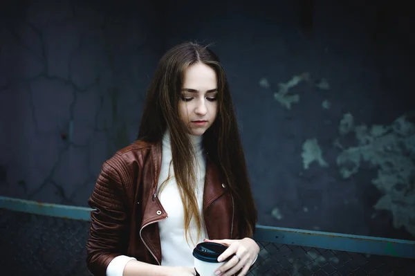 Уличный Портрет Студентки Модной Одежде Синих Джинсах Коричневой Куртке Кофе — стоковое фото
