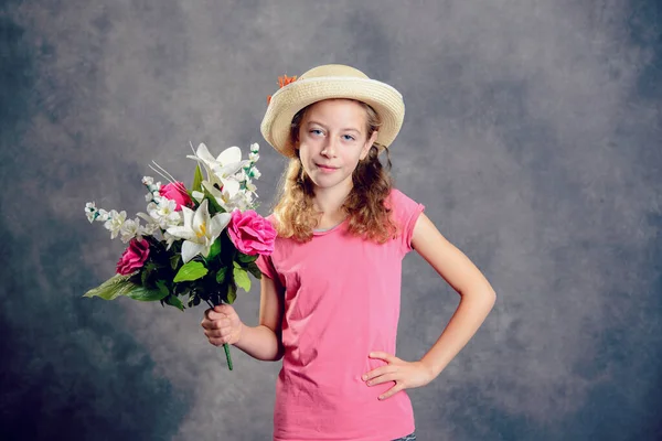 Schönes Blondes Mädchen Mit Strohhut Und Blumenstrauß Vor Grauem Hintergrund — Stockfoto