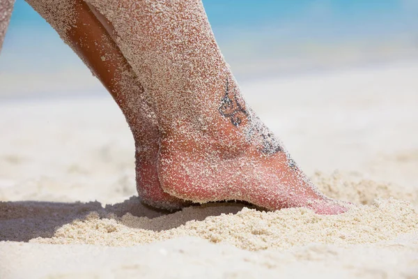 ビーチの砂の上にマニキュア爪を持つ女性の足 — ストック写真