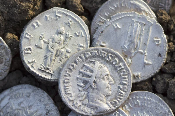 Roman silver coins covered in dirt, ancient denarius