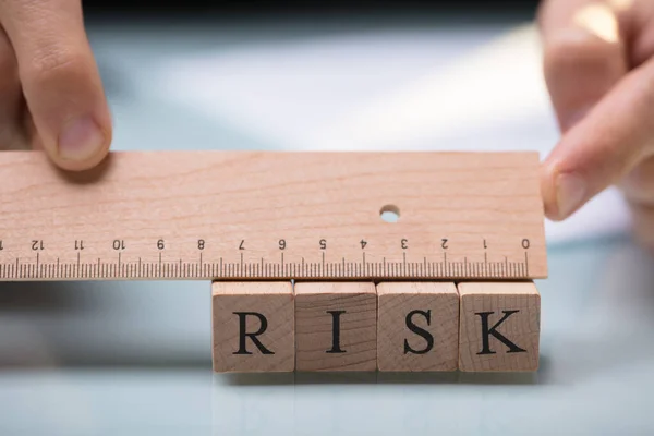Крупный План Руки Предпринимателя Измеряющего Риск Помощью Деревянного Правителя — стоковое фото