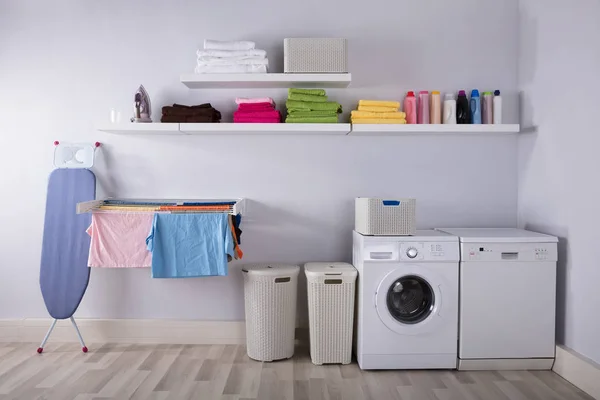 Interior Of Utility Room With Washing Machine And Drying Clothes