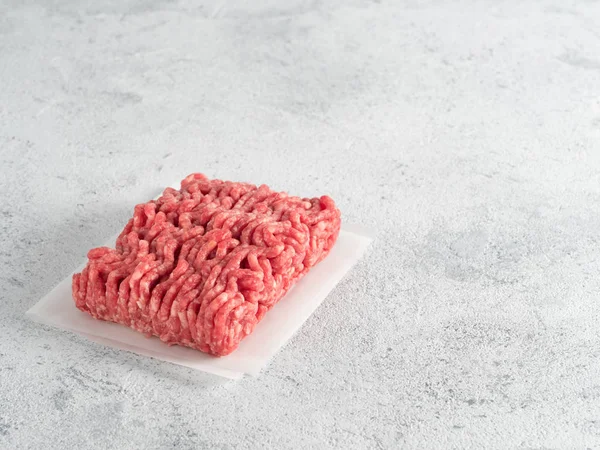 Vers Rauw Gehakt Rundvlees Backing Paper Lichtgrijze Cementondergrond Met Kopieerruimte — Stockfoto