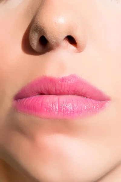 用粉红口红把年轻女子美丽的嘴唇合拢 — 图库照片