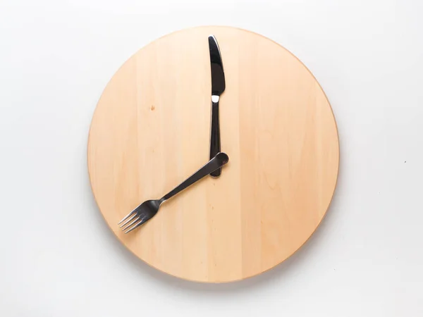 断続的な絶食およびスキップ朝食コンセプト 空のトレイや時計としての刃物とトレンチャー ラウンド木製の白い背景の手します 時間ウィンドウの概念や朝食の時間概念を供給 — ストック写真