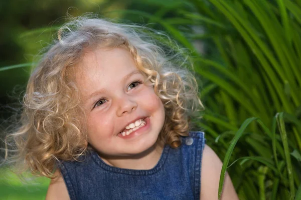 Ein Kleines Hübsches Mädchen Mit Lockigen Blonden Haaren Lacht — Stockfoto
