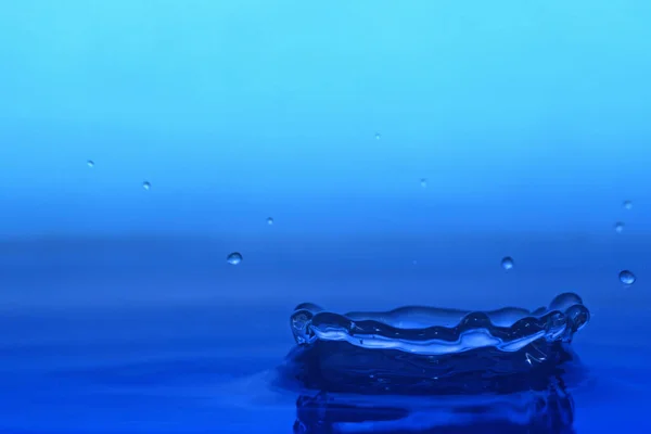 Wasserspritzer Auf Blauem Hintergrund — Stockfoto