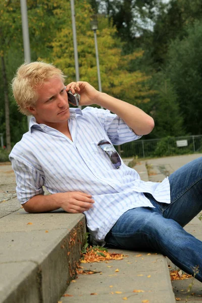 Man Sitter Bänken Och Pratar Mobiltelefon — Stockfoto