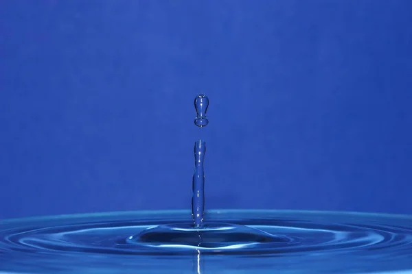 Kropla Wody Spada Niebieskie Tło — Zdjęcie stockowe