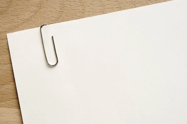 blank paper with a pen on a wooden background