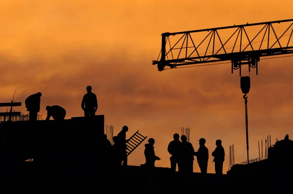 Construction workers in the evening light