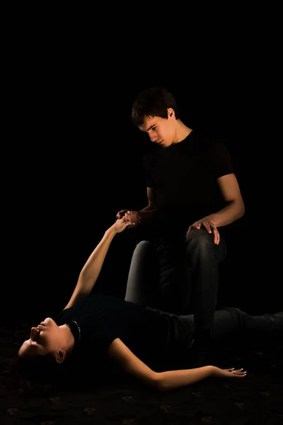 黒いドレスを着た若いカップルが床に座り — ストック写真
