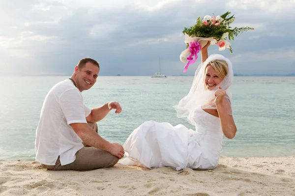 夫妇在海滩上穿着婚纱旅行 — 图库照片
