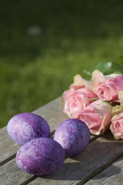Три Фиолетовых Пасхальных Яйца Натюрмортами Роз — стоковое фото
