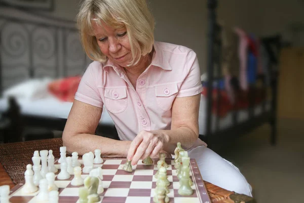 Senior woman plays chess