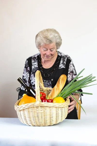 stock image Elderly lady looks at her shopping basket