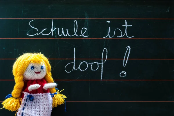 Schoolgirl hand puppet in front of chalkboard