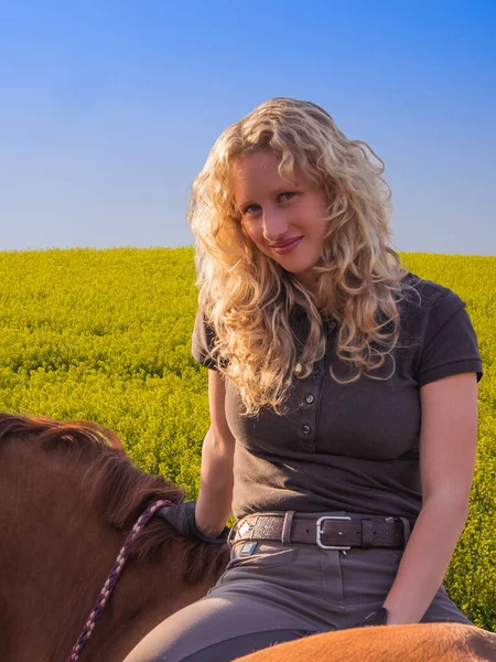 一个年轻的女人和一匹马在田野里 — 图库照片