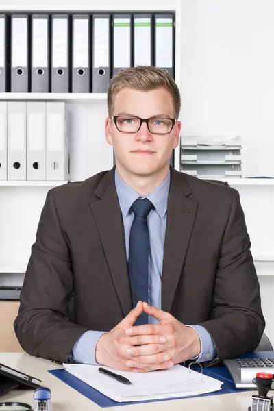 Der Junge Geschäftsmann Mit Brille Sitzt Mit Gefalteten Händen Schreibtisch — Stockfoto