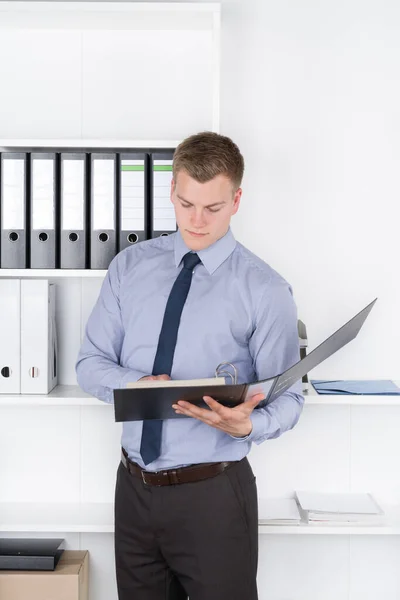 Young Businessman Stands Front Shelf Office Concentrates File Man Looks — Stock Photo, Image