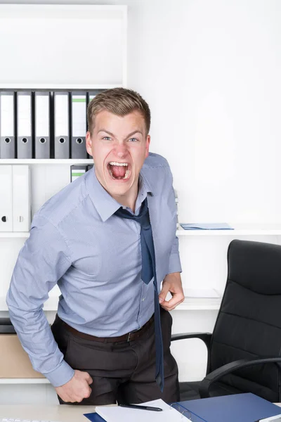 Der Junge Wütende Geschäftsmann Steht Büro Schreibtisch Und Schreit Hintergrund — Stockfoto