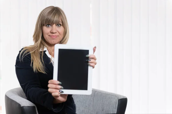 Een Vrouw Gaat Een Stoel Zitten Presenteert Een Tablet Naar — Stockfoto