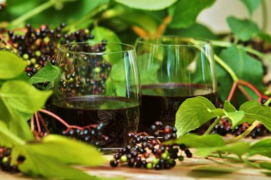 black currant in a glass on a green background clipart