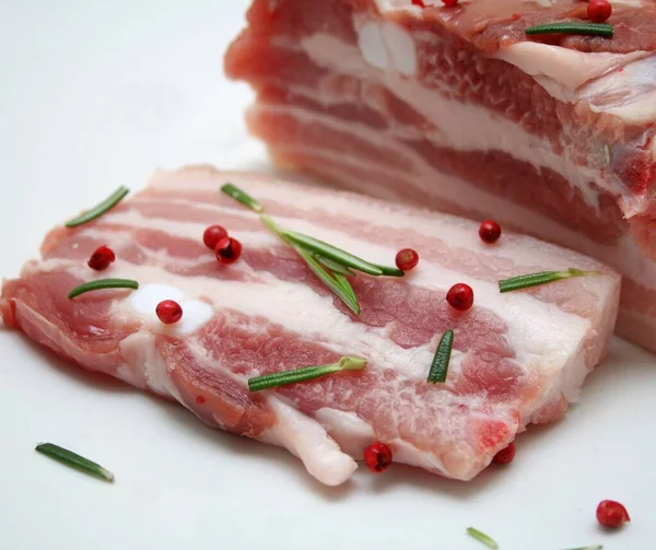 Rohes Schweinefleisch Auf Einem Teller Mit Rosmarin Und Pfeffer — Stockfoto