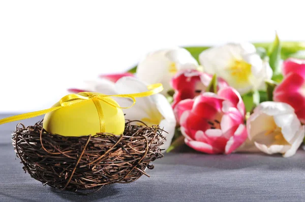 Žluté Velikonoční Vejce Lukem Velikonočním Hnízdě Tulipány Pozadí — Stock fotografie