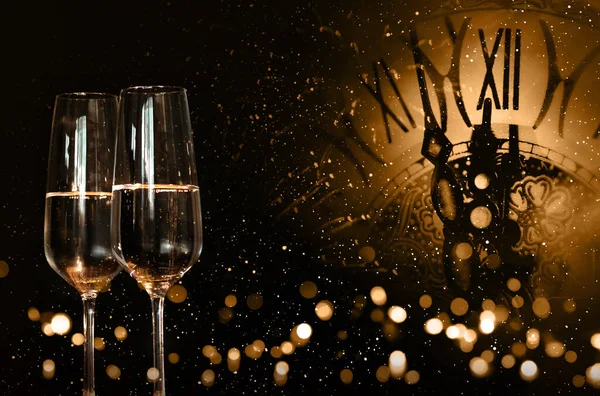 シャンパンで新年のお祝いと雪の結晶と黄金のボケと暗い背景で時計 — ストック写真