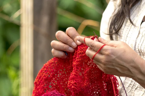 在模糊的背景下用红毛针织的女人的手 — 图库照片