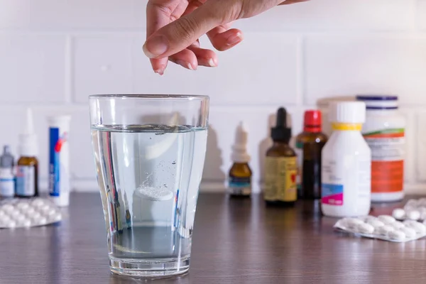 在药丸和药物的背景下 把药丸放在杯子里 水倒入装有药物的杯子里 把药丸扔到水里 — 图库照片