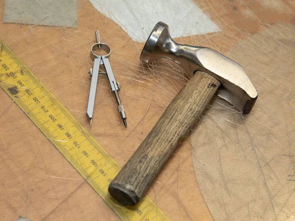 Shoemaker Tools, circle and a measure tape on a desk. Symbolic for craftsman and their workplace.