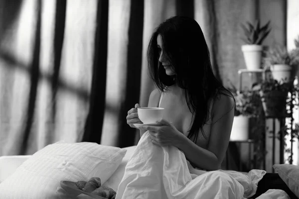 美しい若い女性が朝寝室でお茶を飲んでいて — ストック写真