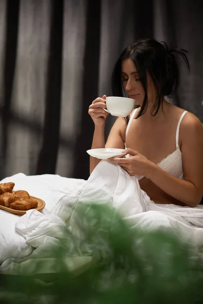 美しい若い女性が朝寝室でコーヒーを飲み — ストック写真